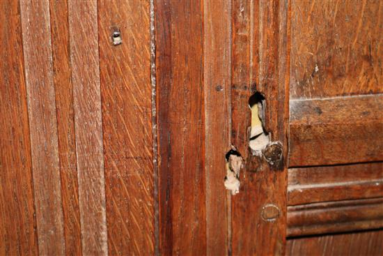 A 17th century oak carved and panelled two door hanging cupboard, W.150cm (a.f.)